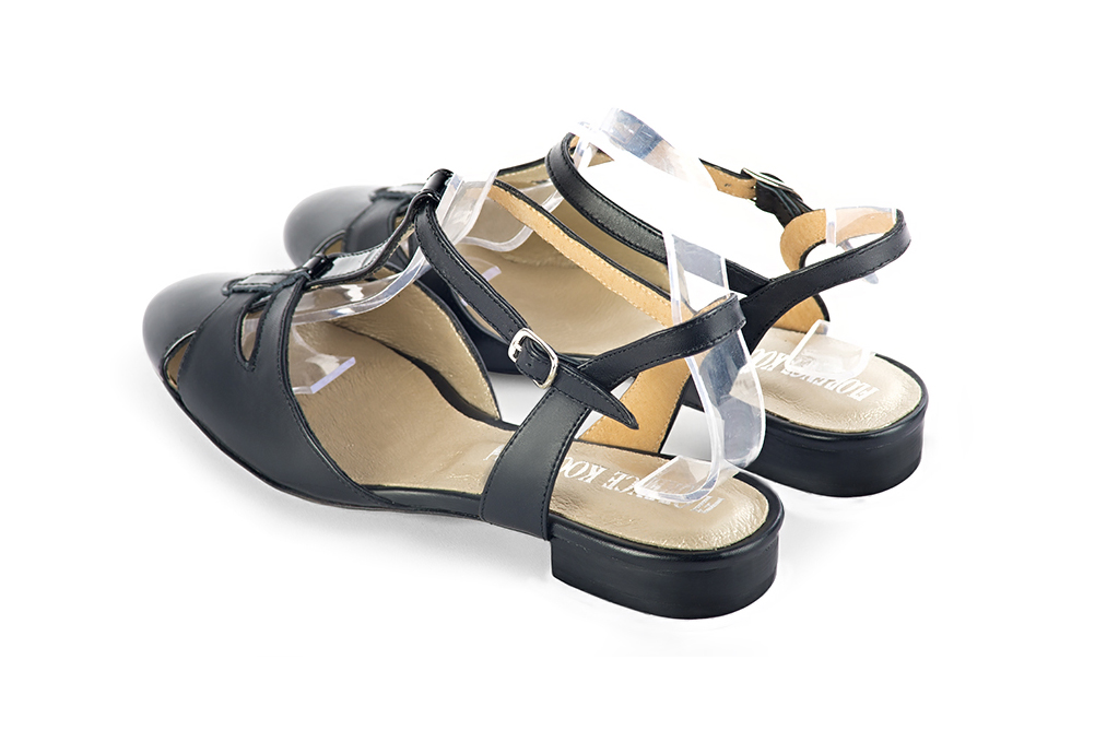 Gloss black women's open back T-strap shoes. Round toe. Flat leather soles. Rear view - Florence KOOIJMAN